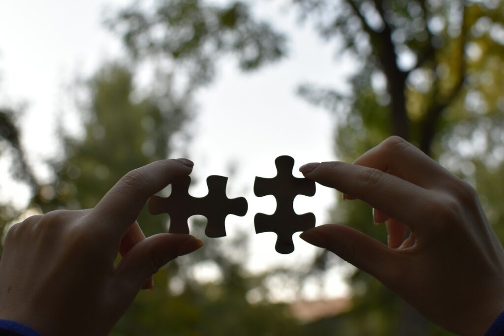 Zwei Hände halten passende Puzzleteile als Sinnbild für eine Unternehmenskooperation