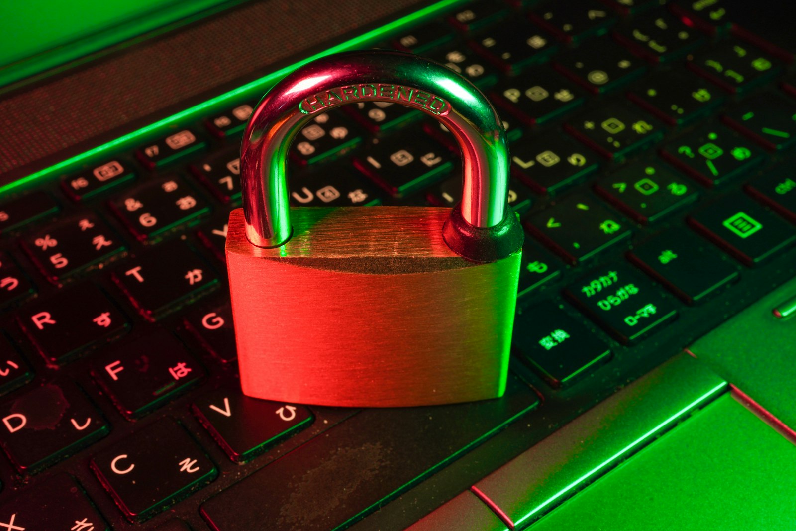 Rotes Vorhängeschloss auf einer schwarzen Computertastatur als Symbol für Cybersicherheit