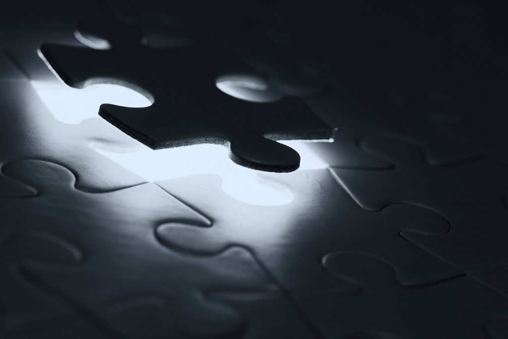 Einzelnes dunkles Puzzleteil über einer passenden Lücke als Symbol für einen Carve-out