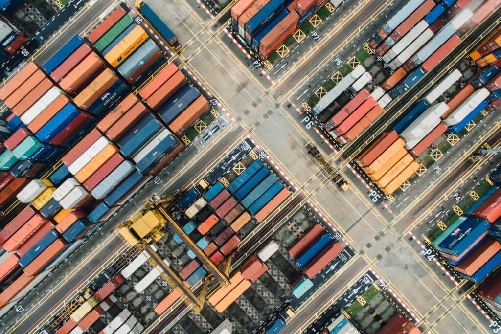Luftaufnahme eines Containerterminals mit farbigen Schiffscontainern in Reihen als Sinnbild für eine Exportstrategie