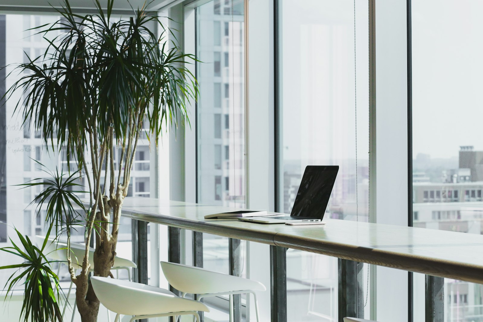 Aufgeräumter Arbeitsplatz mit zugeklapptem Laptop auf einem Holztisch als Symbol für Führen in Teilzeit