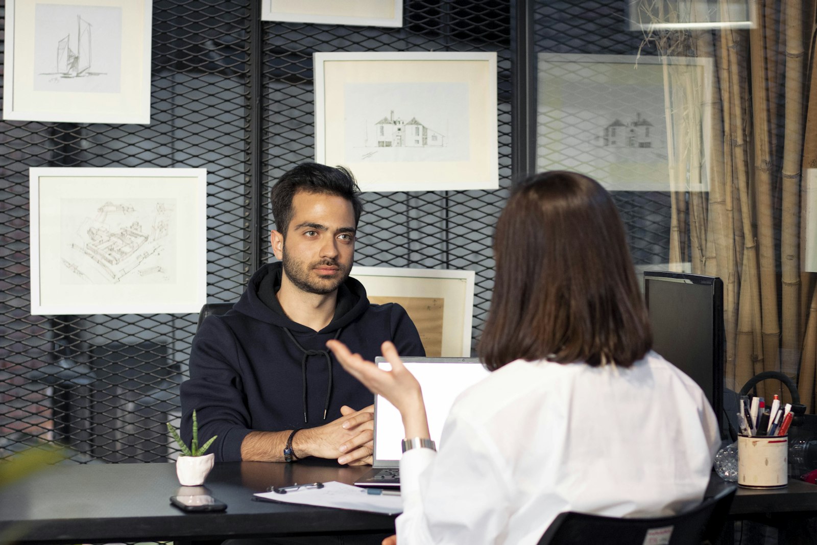 Mitarbeiterin und Vorgesetzter im Gespräch am Schreibtisch während einer Gehaltsverhandlung