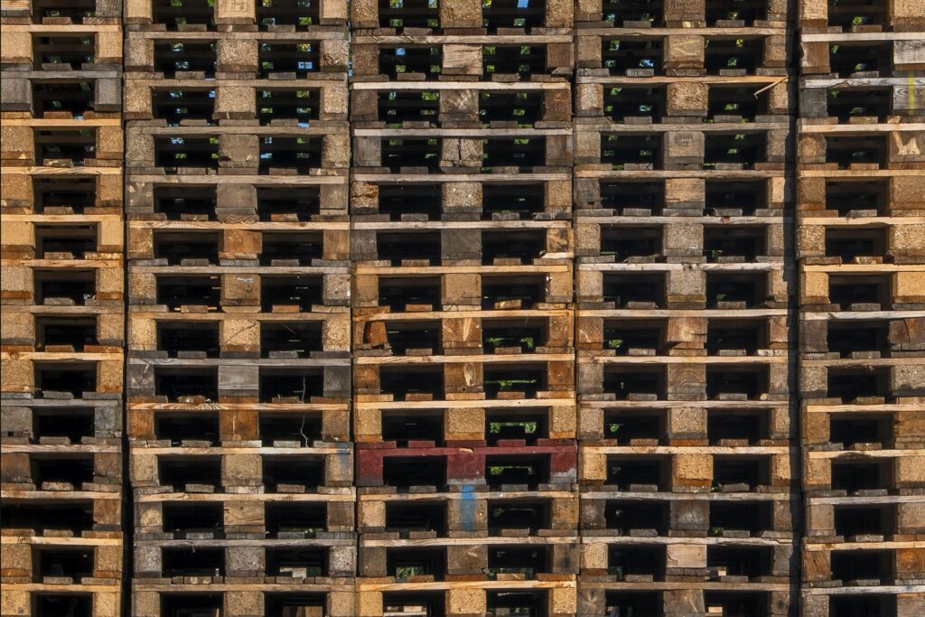 Gestapelte Holzpaletten als Symbol für Liefermengen und Logistikkonditionen