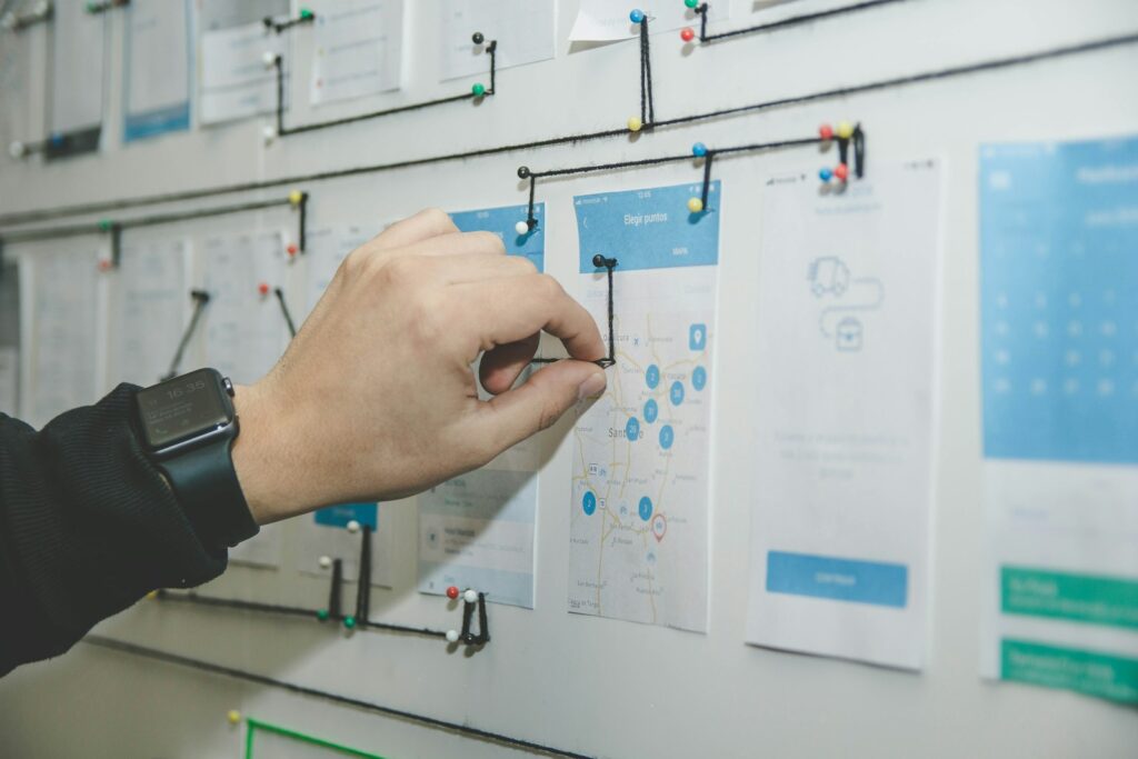 Hand ordnet Haftnotizen auf einer Planungswand – Projektplanung für den ERP-Wechsel