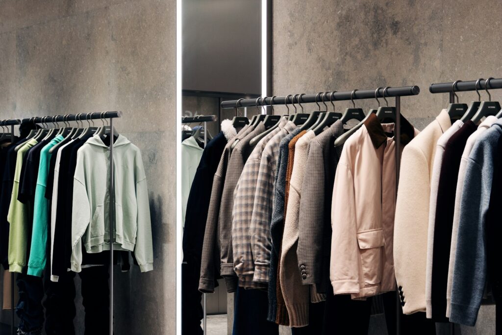 Kleiderständer mit Hemden und Hosen in einem Laden für den Werksverkauf von Textilien