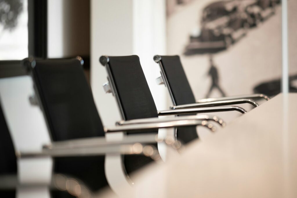 Leere Bürostühle an einem Konferenztisch – geschützter Rahmen für Executive Coaching