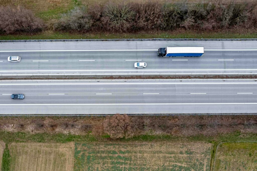 Lkw auf einer Autobahn aus der Luft – Transportdaten gehören zu den Frühindikatoren der Industrie