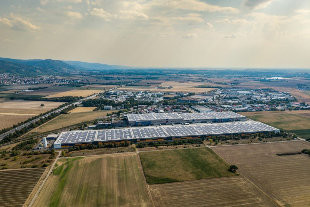 Luftaufnahme einer Industriehalle mit Solarmodulen auf dem Dach zur Senkung der Energiekosten Industrie