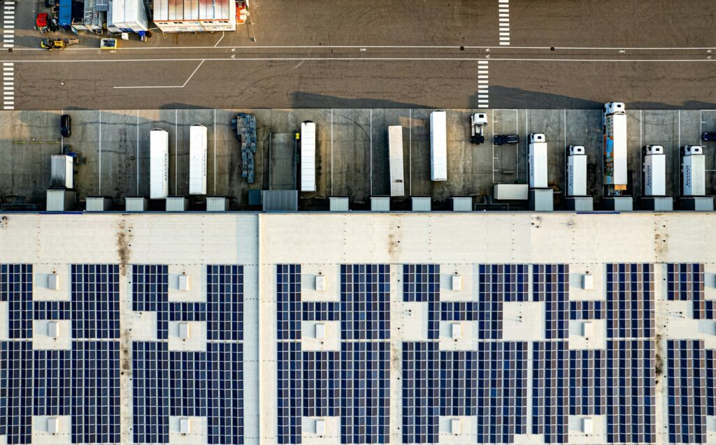 Solar-Carports auf einem Firmenparkplatz aus der Luft – Photovoltaik für Unternehmen nutzt auch Parkflächen