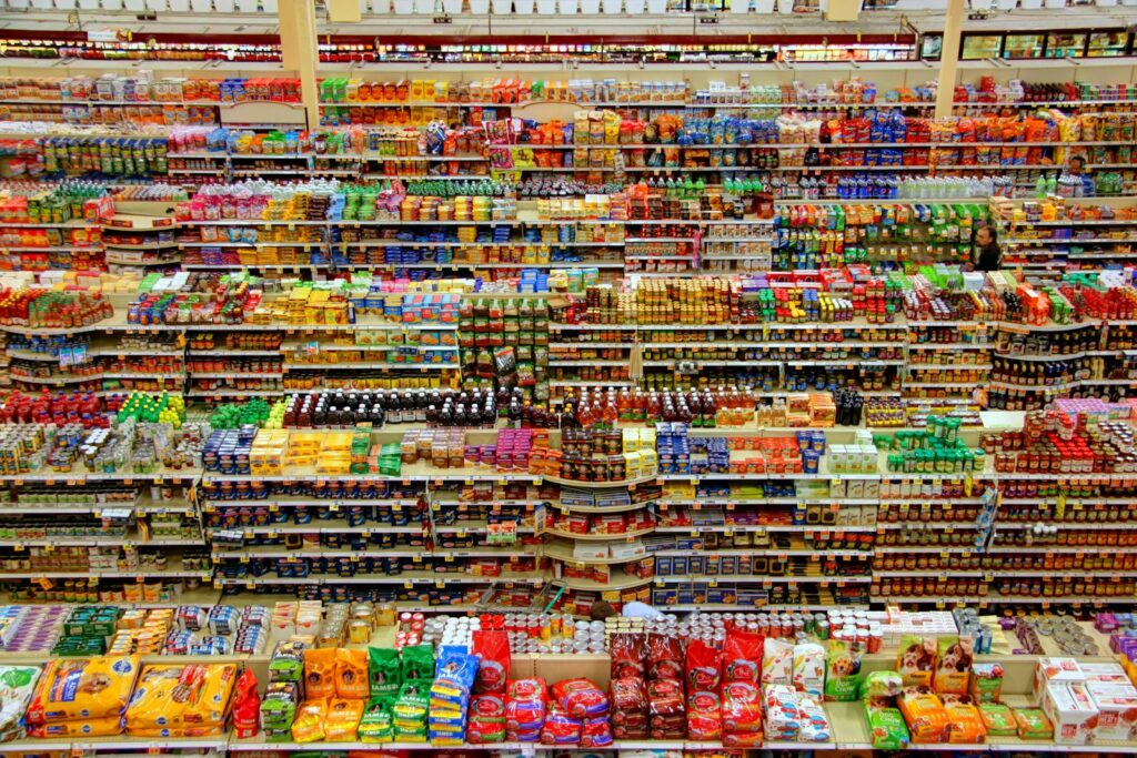 Preisverhandlungen im Handel: Supermarktgang mit gefüllten Warenregalen aus der Vogelperspektive