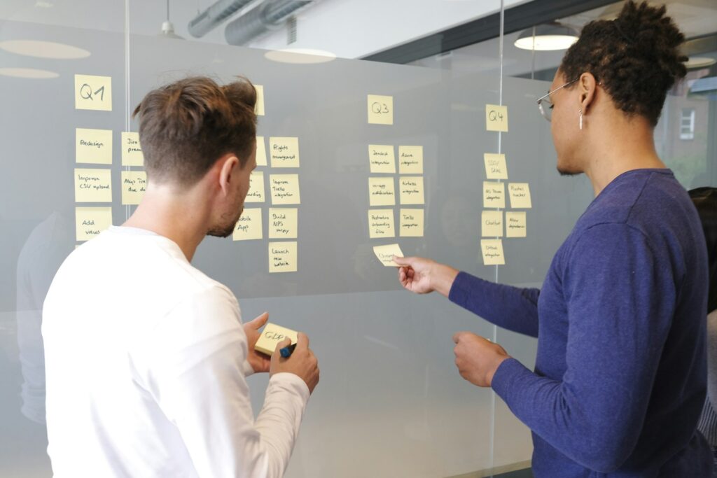 Projektplan mit gelben Haftnotizen an einer Glaswand – typische Arbeitsweise im Interim-Management