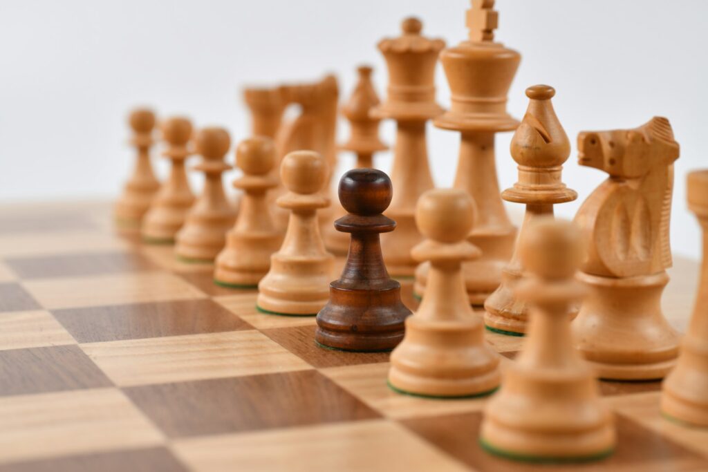 Schachfiguren auf einem Brett als Symbol für strategisches Abwägen von Optionen
