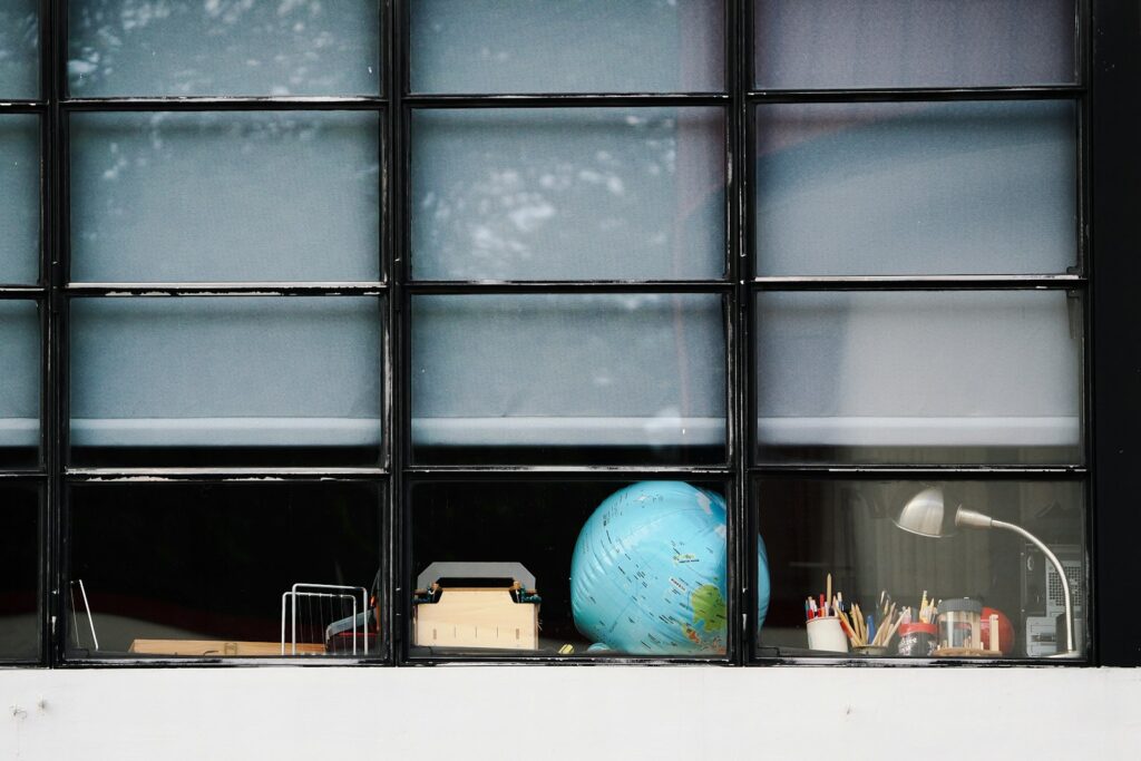 Schreibtisch mit Globus und Lampe am Fenster als Arbeitsplatz für die Exportstrategie