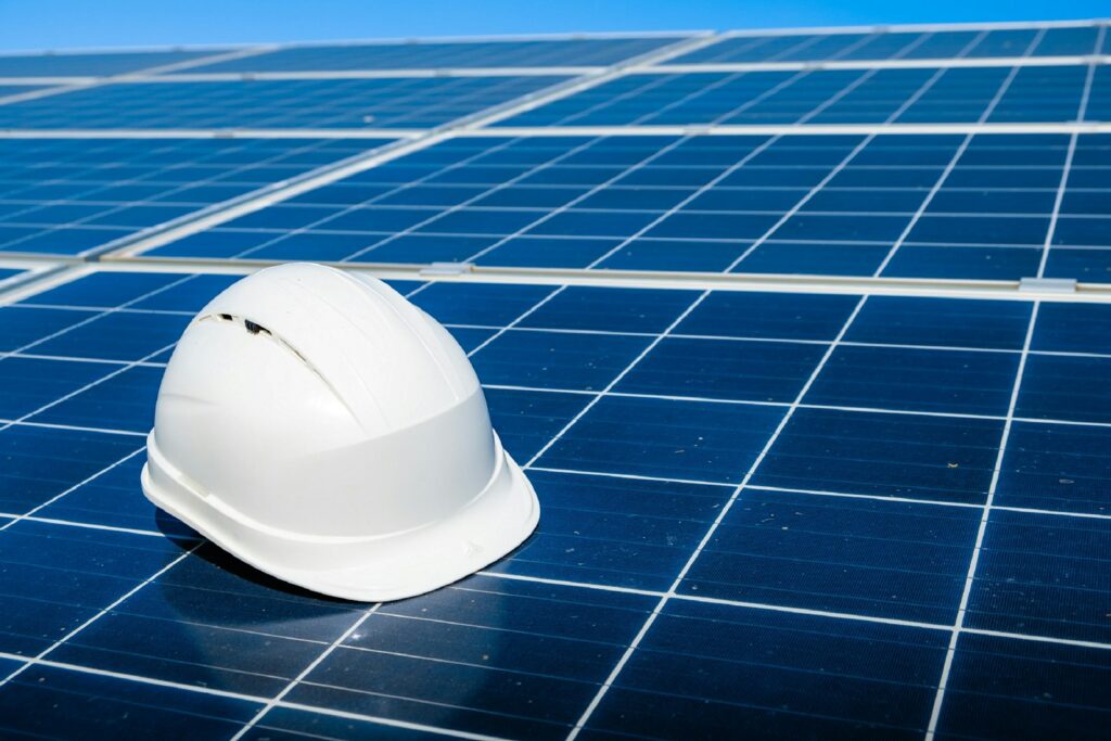 Weißer Schutzhelm auf einem Solarmodul bei der Installation – Photovoltaik für Unternehmen planen