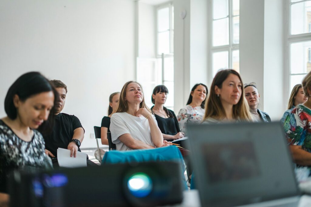 Teilnehmende eines Workshops zur Führungskräfteentwicklung arbeiten gemeinsam in einem hellen Seminarraum